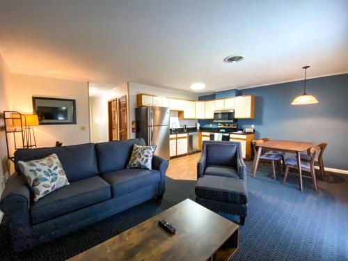 a living room with a blue couch and a table at The Central Downtown Inn Suites in Pittsfield