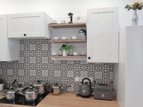 a kitchen counter with pots and pans on a tiled wall at Rezidence 1923 in Kuchařovice