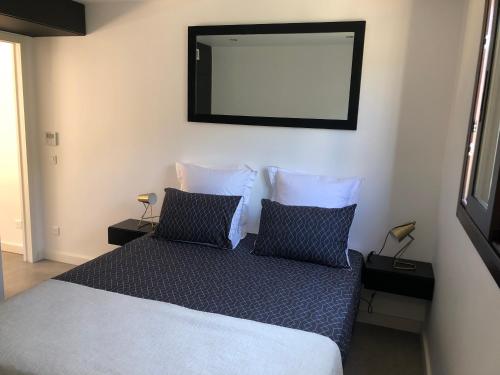 een slaapkamer met een bed met een spiegel aan de muur bij La Verda in Bonifacio