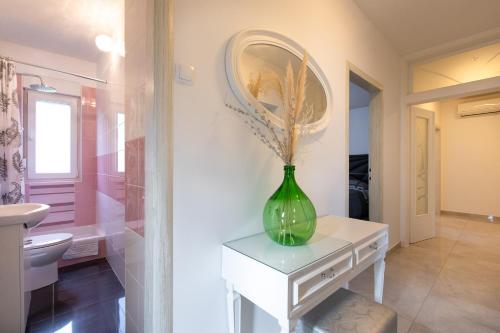 a bathroom with a vase on a table with a mirror at Villa Nina Baška in Baška