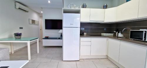 a kitchen with white cabinets and a white refrigerator at Marjal 3 Beach in Guardamar del Segura