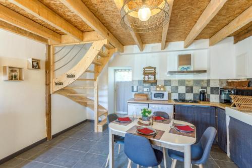 une cuisine avec une table et des chaises ainsi qu'un escalier dans l'établissement Ty Armor - Jolie Maison avec Jardinet, à Plumaudan