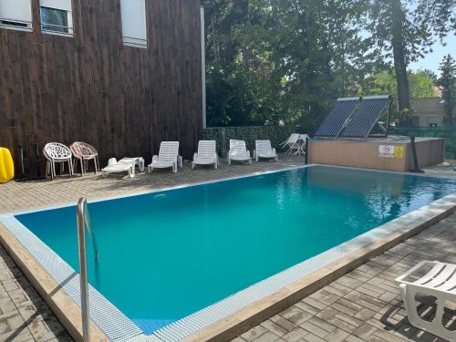 a blue swimming pool with chairs and a fence at LIDO nappali + 3 háló apartman in Balatonlelle