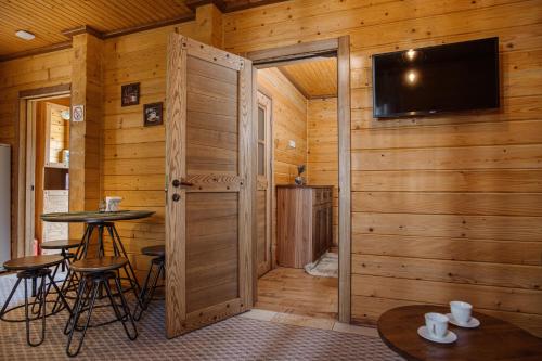a room with a wooden wall with a door and a table at ЕкоСадиба Пан Атаман in Skhidnitsa