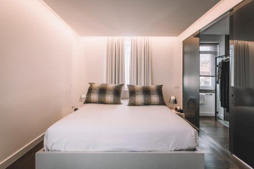 a bedroom with a white bed with two pillows at QUINTA TORRINHA LUXODREAM Apartment in Funchal