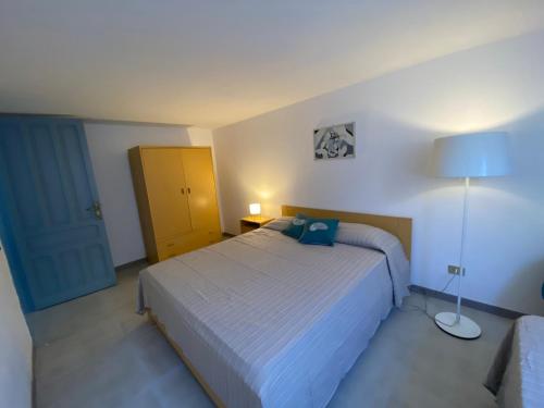 a bedroom with a bed and a lamp in it at Casa Teresa in Porto Pino