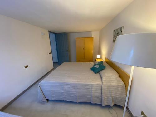 a bedroom with a bed with a green pillow on it at Casa Teresa in Porto Pino