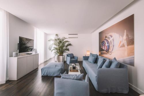 a living room with a blue couch and chairs at QUINTA TORRINHA LUXODREAM Apartment in Funchal