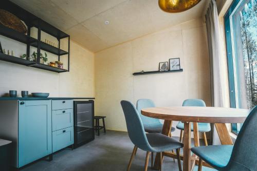 a dining room with a table and blue chairs at Venejoen Piilo - Loimu in Kontiolahti