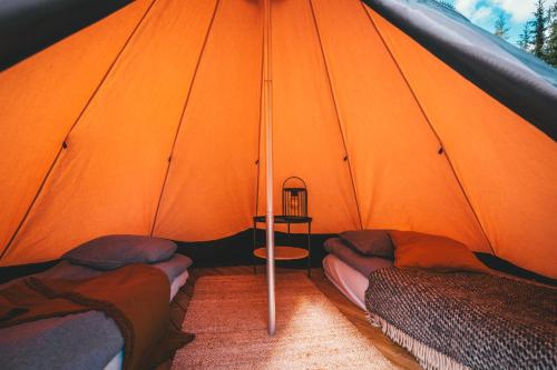an orange tent with two beds in it at Venejoen Piilo - Loimu in Kontiolahti