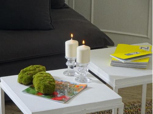 - une table basse blanche avec deux bougies dans l'établissement Un Appart en Ville, à Nice