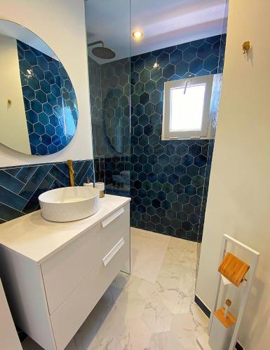 a bathroom with a sink and a blue tiled wall at La Siesta in Estepona