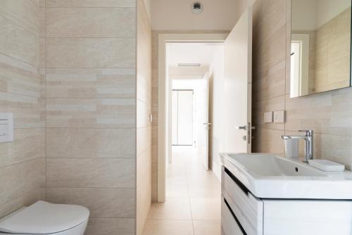 bagno con servizi igienici bianchi e lavandino di LUVI - Flavio Gioia a Milano