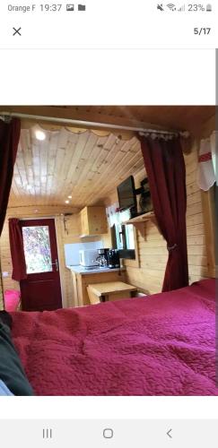 - une chambre avec un lit doté d'un couvre-lit rouge dans l'établissement La roulotte au cœur de la côte d'opale, à Marquise