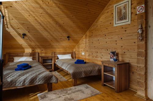 a room with two beds in a log cabin at ЕкоСадиба Пан Атаман in Skhidnitsa