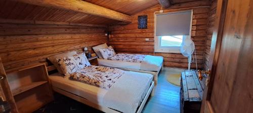 a bedroom with two beds in a wooden cabin at Ønskedrømmen hytteutleie in Brandbu