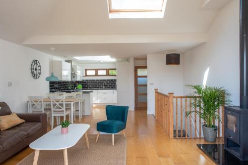 a living room and kitchen with a couch and a table at Modern, well placed house walkable to beach & town in Lyme Regis