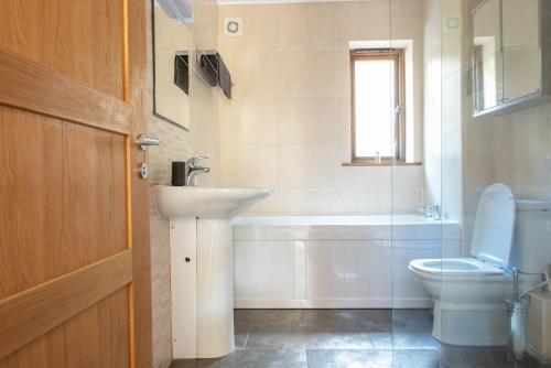 Un baño con lavabo, inodoro y bañera. en 1 Dorset Mews, en Lyme Regis