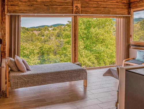 a bedroom with a bed in front of a large window at Apartmani Lunija in Gornji Milanovac