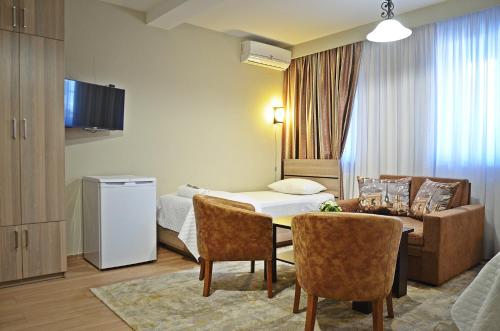 トビリシにあるApartment Paysageのベッド、テーブル、椅子が備わるホテルルームです。