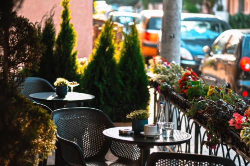 two tables and chairs on a balcony with plants at Living Rooms in Skopje
