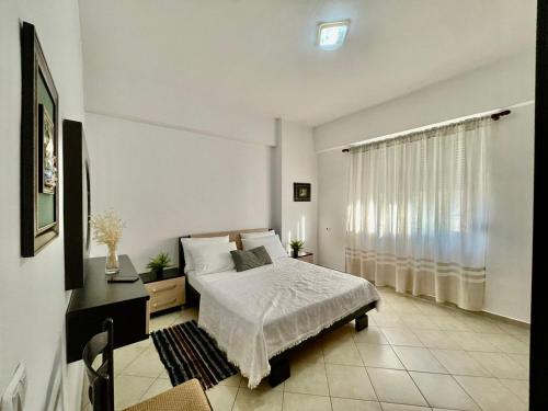 um quarto branco com uma cama e uma janela em Apartment Orik em Orikum