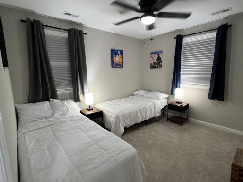 um quarto com 2 camas e uma ventoinha de tecto em Experience Raleigh NC 8 minutes from the heart em Raleigh