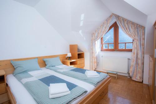 Cama grande en habitación con ventana en Apartment Tinka Kranjska Gora, en Kranjska Gora