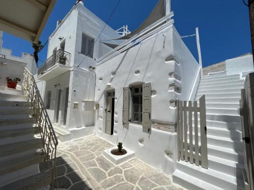 a white house with white stairs and a window at Cycladic Rooftop House in the Heart of Parikia in Parikia