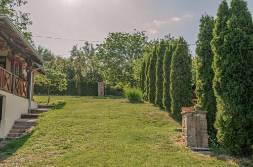 a row of trees in a yard next to a house at Apartmani Lunija in Gornji Milanovac