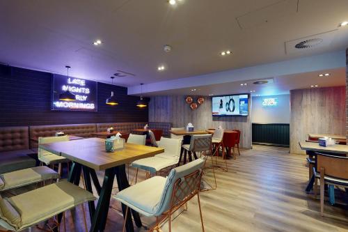 a dining room with tables and chairs in a restaurant at Village Hotel Bournemouth in Bournemouth