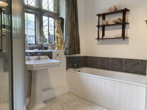 y baño con lavamanos, bañera y lavamanos. en Riber Hall Manor en Matlock Bank