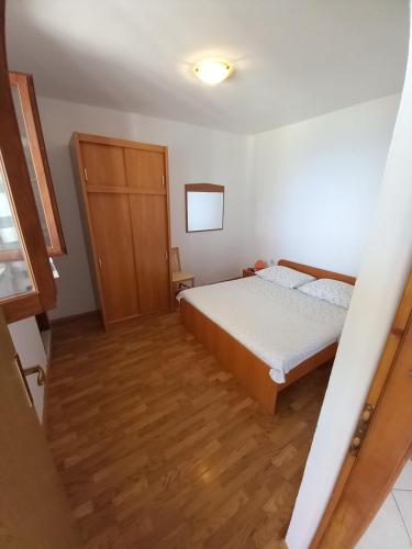 a small bedroom with a bed and a wooden door at House Marina 30m from the sea in Sveta Nedelja