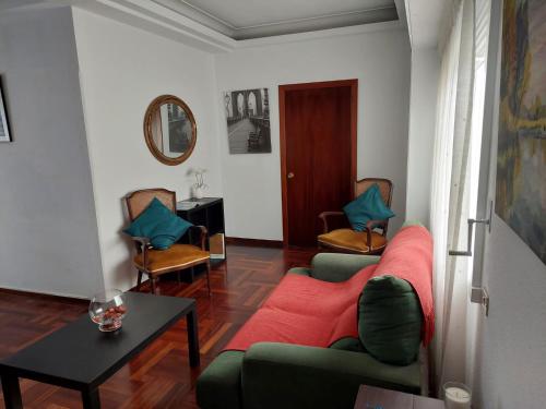 sala de estar con sofá, sillas y mesa en Casa céntrica. A Coruña a 200m de la playa Riazor, en A Coruña