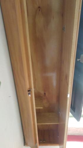 a wooden cabinet with the door open on a room at Parrot House San Antonio in Cali