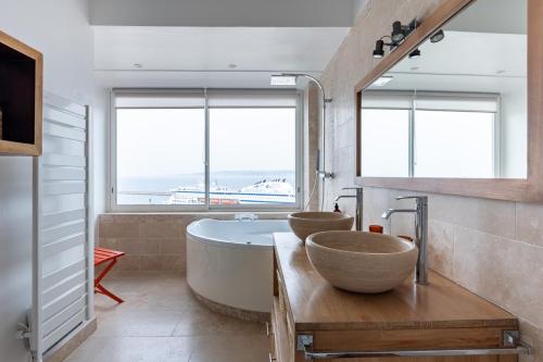 a bathroom with a tub and a sink and two windows at BLUE BAY - superbe vue sur le Vieux Port in Marseille