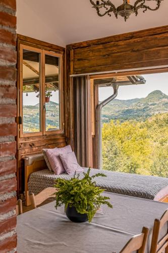 a room with two beds and a table with a plant at Apartmani Lunija in Gornji Milanovac