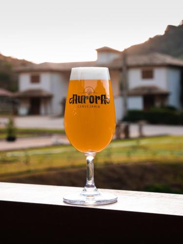 a glass of beer sitting on a ledge at Pousada Bela Aurora in Venda Nova do Imigrante