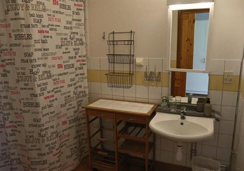 a bathroom with a sink and a shower curtain at HusHotellHunge AB in Bräcke