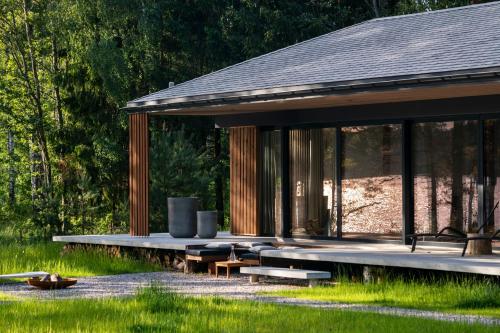 a pavilion with benches and tables in the grass at Villa The Lake in Mindūnai
