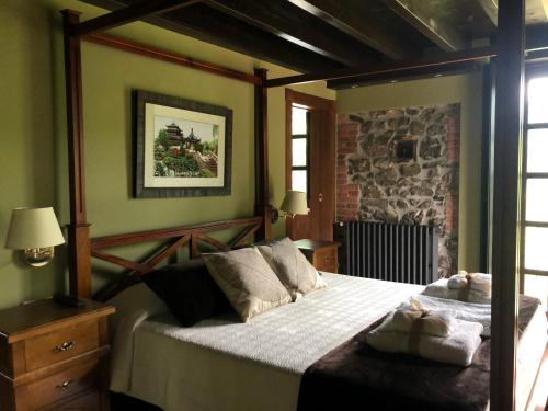 a bedroom with a bed and a stone wall at Casa Escuela de Torín - La Casona de Torin in Torín