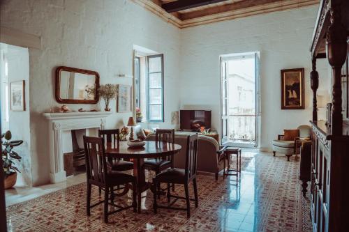 una sala da pranzo con tavolo e sedie di Santa Margerita Palazzino Apartment a Cospicua