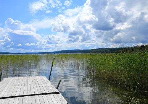 a dock on a body of water with clouds in the sky at HusHotellHunge AB in Bräcke