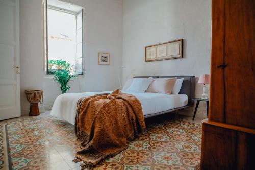 una camera da letto con un letto coperto di Santa Margerita Palazzino Apartment a Cospicua