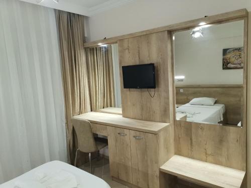 Habitación de hotel con espejo y escritorio con TV. en Melodi Club Apart, en Davutlar