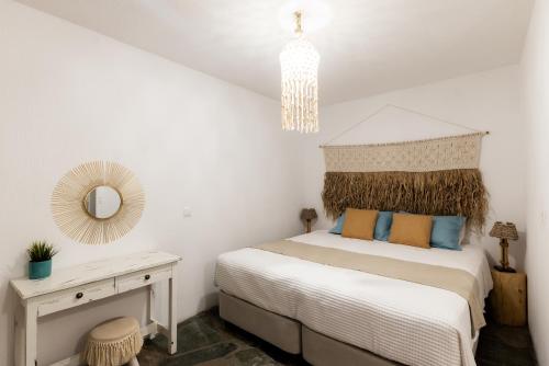 a bedroom with a bed and a mirror and a table at Anna's Apartments in Mikonos