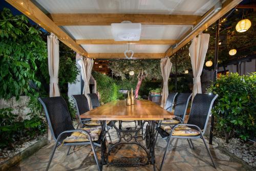 an outdoor dining room with a wooden table and chairs at Apartments Mario 2 in Pula