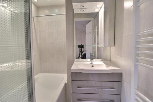 une salle de bain blanche avec un lavabo et une douche dans l'établissement Résidence Grande Rosière, à Méribel