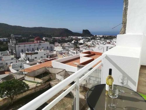 a bottle of wine sitting on a table on a balcony at Alojamientos Harizan in Agaete