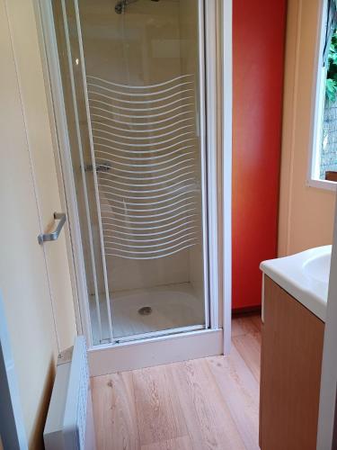 une douche en verre dans une salle de bain avec un lavabo dans l'établissement Charmant Bungalow à Saint-Pierre-d'Oléron avec Jardin, à Saint-Pierre-dʼOléron
